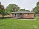The backyard offers a screened porch, level lawn, and beautiful landscaping for outdoor enjoyment and relaxation at 407 S Buckoak St, Stanley, NC 28164