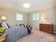 Well-lit bedroom with a comfy bed, dresser, and windows at 407 S Buckoak St, Stanley, NC 28164