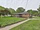 Charming brick home with a screened-in porch, lush lawn, and mature landscaping at 407 S Buckoak St, Stanley, NC 28164