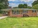Charming single-story brick home with a well-manicured front yard, inviting porch, and convenient covered carport at 407 S Buckoak St, Stanley, NC 28164