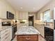 Granite counters with a kitchen island, modern appliances, and a view into the laundry room at 407 S Buckoak St, Stanley, NC 28164