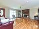 Spacious living room featuring a cozy brick fireplace, hardwood floors, and ample natural light from the large window at 407 S Buckoak St, Stanley, NC 28164