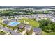 An elevated view showcasing a community with varied home styles, a community pool, and lush greenery at 463 Hunton Forest Nw Dr, Concord, NC 28027