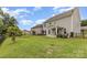 A view of the home's backyard, showcasing the black fence, green grass, and patio at 463 Hunton Forest Nw Dr, Concord, NC 28027