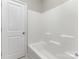 A clean, white tub and shower combination with a white door in the bathroom at 463 Hunton Forest Nw Dr, Concord, NC 28027