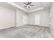 Bedroom with tray ceiling, ceiling fan, neutral walls, gray carpet, and two windows at 463 Hunton Forest Nw Dr, Concord, NC 28027