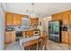 Well-equipped kitchen with wooden cabinets, stainless steel refrigerator, and a dining area with natural light at 4810 Shea Ct, Monroe, NC 28110