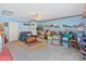 Cozy living room featuring blue walls, a ceiling fan, and carpet flooring, filled with furniture and storage boxes at 4810 Shea Ct, Monroe, NC 28110