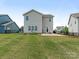 Well-maintained backyard with a concrete patio, planting beds, lush green grass, and black metal fence at 4912 Grace View Dr, Pineville, NC 28134