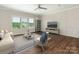 Open-concept living room has sleek, modern furnishings and decorative paneling around the TV feature wall at 4912 Grace View Dr, Pineville, NC 28134