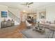 Open-concept living room with hardwood floors leading to the kitchen and staircase in the home at 4912 Grace View Dr, Pineville, NC 28134