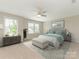 Bright main bedroom featuring neutral tones, two windows, a ceiling fan, and a decorative rug at 4912 Grace View Dr, Pineville, NC 28134