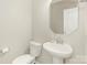 Well-lit powder room featuring a pedestal sink, toilet, and decorative mirror for guests' convenience at 4912 Grace View Dr, Pineville, NC 28134