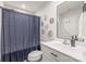 Bathroom with floral decor and a shower with a blue shower curtain at 5023 Daybell St, Charlotte, NC 28214