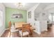 Dining room with an accent wall, natural wood table, and a view of the kitchen at 5023 Daybell St, Charlotte, NC 28214