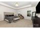 Bright main bedroom featuring a tray ceiling, light carpet, and a seating area bench at 5043 Baileys Run Dr, Rock Hill, SC 29732