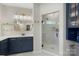Modern bathroom featuring navy cabinets, a glass shower, and gold fixtures at 5050 Havencrest Dr, Fort Mill, SC 29715