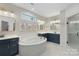 Beautiful bathroom featuring dual vanities, a soaking tub, and a glass-enclosed shower at 5050 Havencrest Dr, Fort Mill, SC 29715