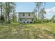 Two story home with a green lawn and a seating area in the backyard surrounded by mature trees at 507 Newsome Rd, Salisbury, NC 28146