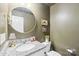 Stylish half bathroom with granite countertop, round mirror and warm color scheme at 507 Newsome Rd, Salisbury, NC 28146