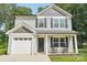 Charming two-story home featuring gray siding, black shutters, inviting front porch with rocking chairs and attached one-car garage at 507 Newsome Rd, Salisbury, NC 28146