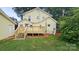 The backyard has a wooden deck, green grass, and mature trees surrounding the home at 522 Alexander St, Statesville, NC 28677