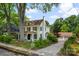 Quaint two-story yellow home with mature trees, a detached garage and driveway, and a well-manicured lawn at 522 Alexander St, Statesville, NC 28677
