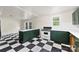 View of an open kitchen showcasing emerald cabinetry, white countertops and a classic checkered floor at 522 Alexander St, Statesville, NC 28677