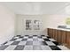 Sunlit room showcasing a black and white checkered floor and a wooden kitchen bar with white countertop at 522 Alexander St, Statesville, NC 28677