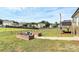 The backyard boasts a brick firepit area, lush green lawn, and a spacious wooden deck perfect for outdoor relaxation at 5333 Lake Glenn Dr, Stanfield, NC 28163