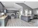 Well-lit kitchen with stainless steel appliances, gray cabinets, island with barstool seating, and hardwood laminate flooring at 5333 Lake Glenn Dr, Stanfield, NC 28163