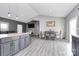 Open-concept kitchen into living area with gray cabinets, island with seating, and plenty of natural light at 5333 Lake Glenn Dr, Stanfield, NC 28163