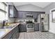 Well-equipped kitchen with stainless steel appliances, gray cabinets, and laminate flooring at 5333 Lake Glenn Dr, Stanfield, NC 28163