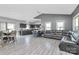 Open-concept living room with modern floors, seamless kitchen and dining area, and vaulted ceiling at 5333 Lake Glenn Dr, Stanfield, NC 28163