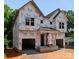 New construction home with attached garages, framed with Tyvek HomeWrap under a blue sky at 5615 Lantana Ave # B, Charlotte, NC 28205