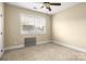 Neutral bedroom featuring a ceiling fan and a large window for natural light at 6011 Nw Village Nw Dr, Concord, NC 28027