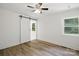 Bright bedroom featuring hardwood flooring, modern sliding barn door, and bright light at 615 & 625 Irish Potato Rd, Concord, NC 28025