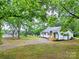 Charming home surrounded by trees, featuring a gravel driveway and a well-manicured lawn at 615 & 625 Irish Potato Rd, Concord, NC 28025