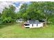 Aerial view of a quaint white home with mature trees on a lush green lawn at 615 & 625 Irish Potato Rd, Concord, NC 28025