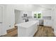 Bright, modern kitchen with an island, stainless appliances, and laminate wood flooring at 615 & 625 Irish Potato Rd, Concord, NC 28025
