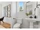 Elegant half bathroom with a pedestal sink, modern toilet, and stylish wall decor at 621 Poindexter Dr, Charlotte, NC 28209