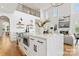 Bright, modern kitchen features an island with a waterfall countertop, stainless steel appliances, and hardwood floors at 621 Poindexter Dr, Charlotte, NC 28209