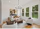Bright living room featuring a neutral sofa, swivel chairs, and three large windows at 621 Poindexter Dr, Charlotte, NC 28209