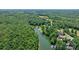 Wide aerial shot showcases the lake and verdant forest surrounding waterfront properties at 6256 Monford Dr, Conover, NC 28613