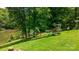 Picturesque backyard featuring a lush green lawn, steps to the lake, and mature trees at 6256 Monford Dr, Conover, NC 28613