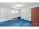 A cozy bedroom with blue carpet, brick walls, and a window with natural light creates a comforting space at 6256 Monford Dr, Conover, NC 28613