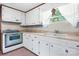 Charming kitchen with white cabinets, vintage oven, and a sink under a window, creating a cozy and functional space at 6256 Monford Dr, Conover, NC 28613