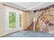 Carpeted staircase next to a stone wall and a door to the exterior with natural light create an inviting entrance at 6256 Monford Dr, Conover, NC 28613