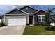 Charming single-story home showcasing a stone facade, two-car garage and well-manicured lawn at 640 Yellow Birch Dr, Locust, NC 28097