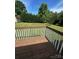 Spacious wooden back deck overlooking a lush green lawn and mature trees on a sunny day at 667 Blossom Hill Rd, Lincolnton, NC 28092